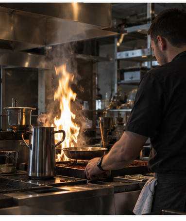 Un cuisinier travaille au feu, devant les fourneaux